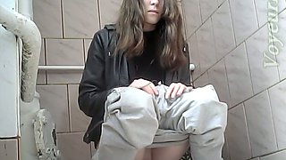 Beautiful tall brunette chick in white jeans pisses in the toilet