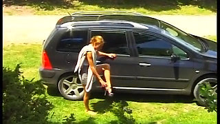 Big boobed MILF fingering her pussy in nature