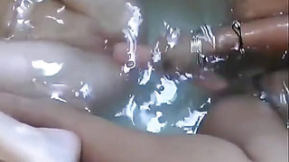 Two beautiful lesbians masturbate their pussies while relaxing in the tub