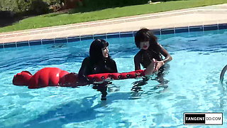 TANGENTOD Women in Black Catsuits Float Red Latex Encased Figure on Inflatable Rubber Pool Toy
