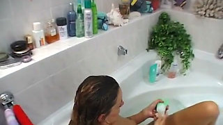 Small titted brunette is rubbing her hairy pussy in the bathroom