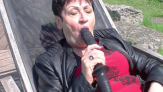Granny enjoys dildo in garden